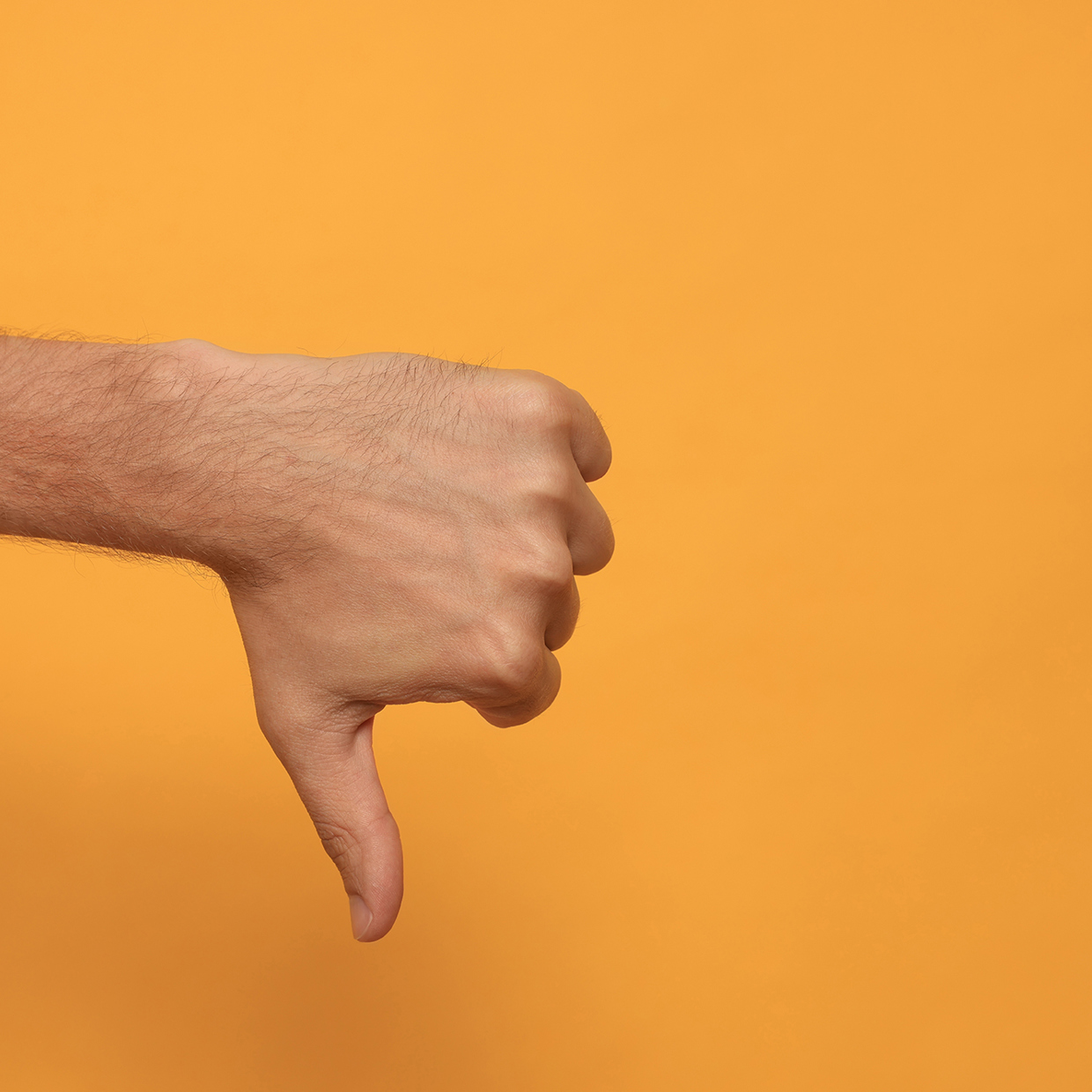 Daumen runter vor gelbem Hintergrund